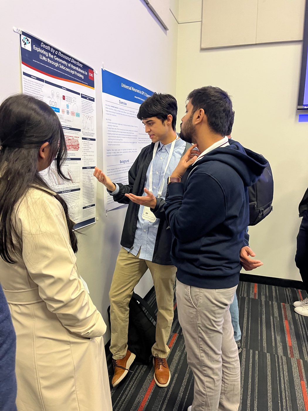 Algoverse student discussing research poster with attendees at COLM 2025