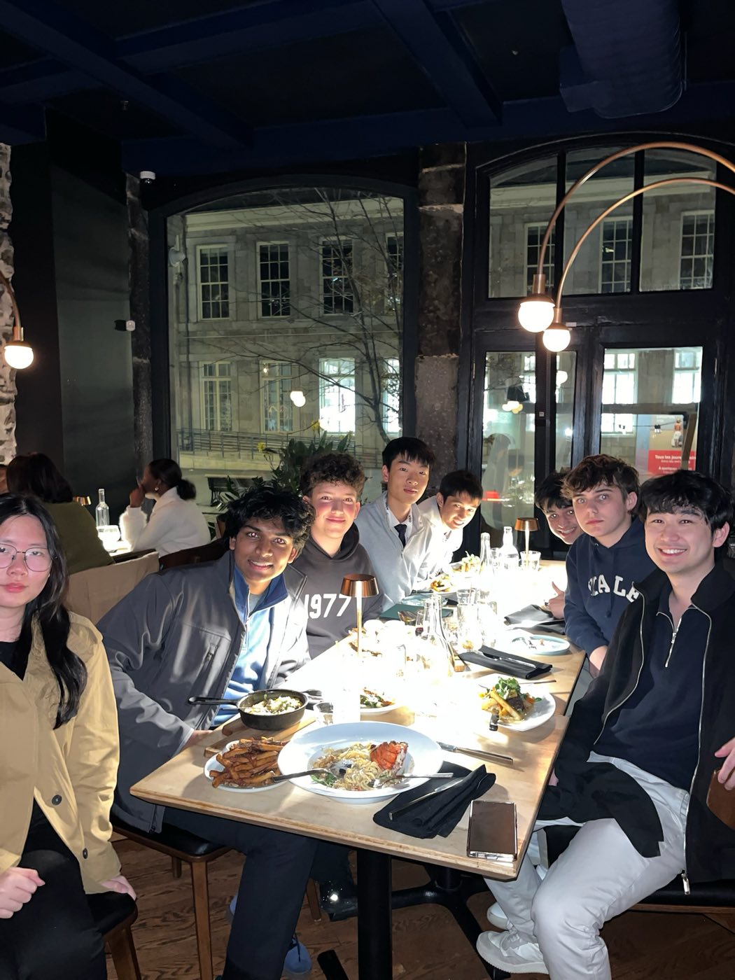 Algoverse team gathered around a dinner table at COLM 2025