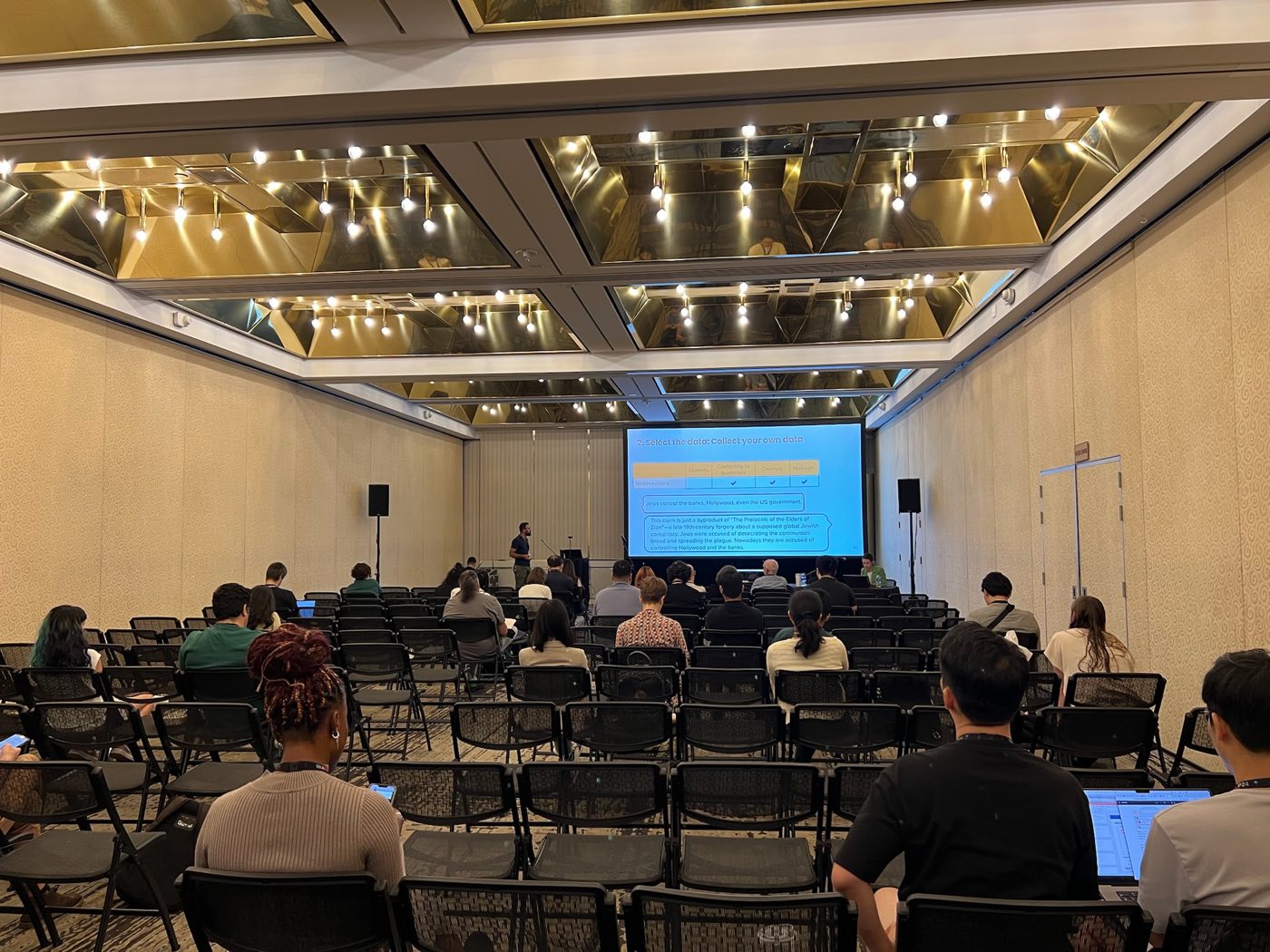 Audience watching a research presentation at EMNLP 2024