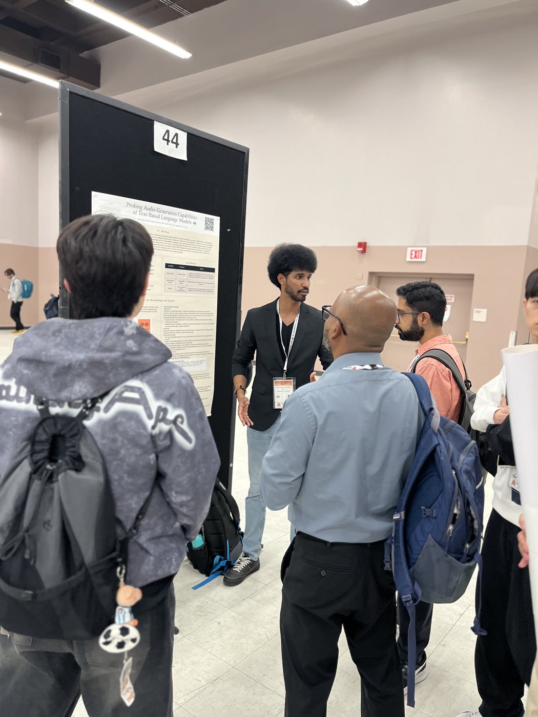 Algoverse student discussing research poster with attendees at NAACL 2025