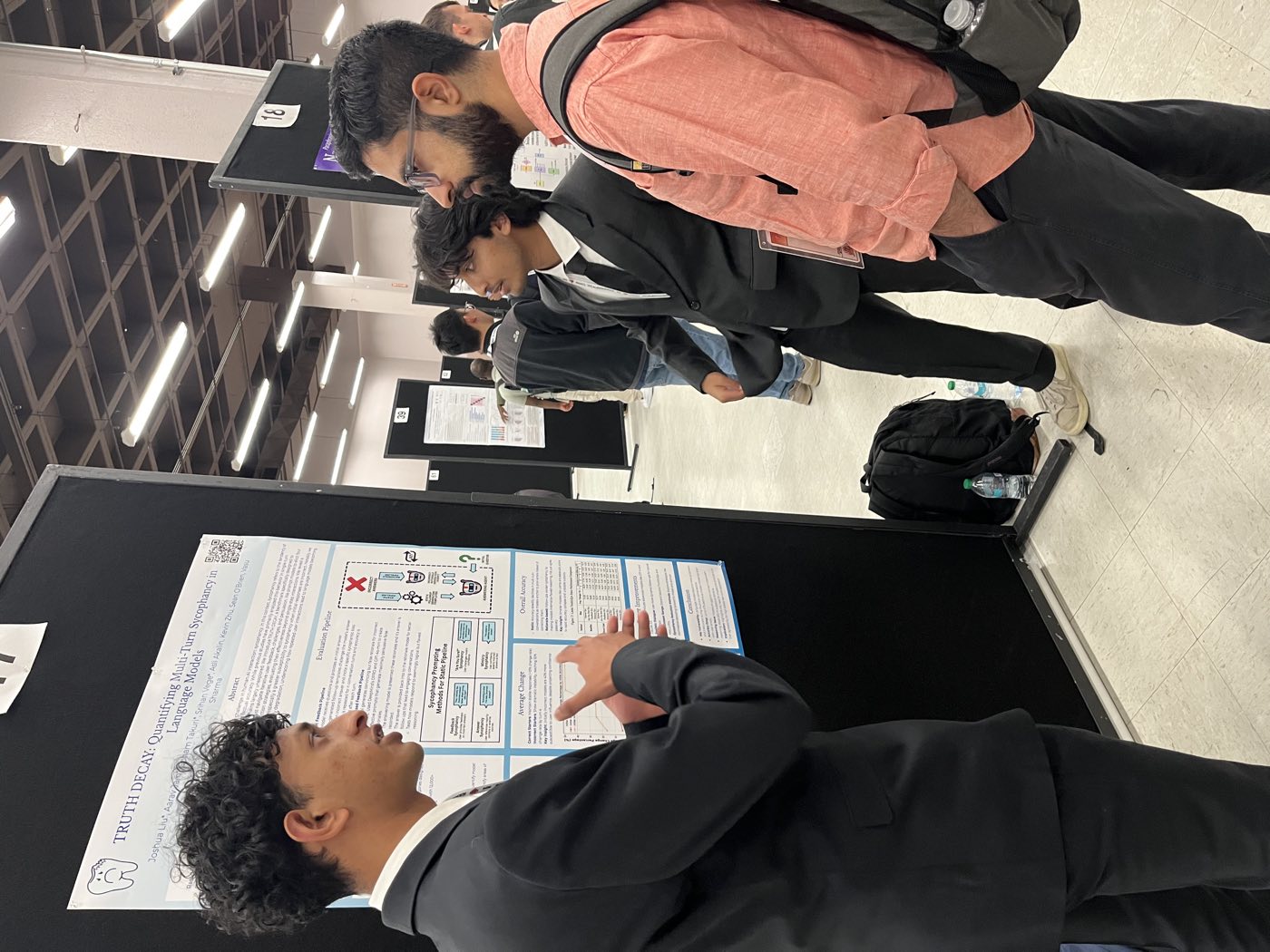 Algoverse student in suit presenting research poster at NAACL 2025